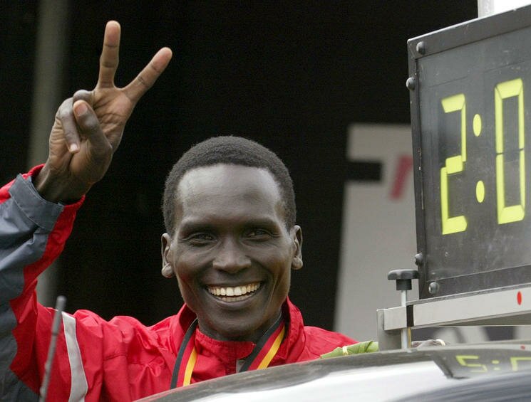 Paul Tergat from Kenya flashes a victory sign next to a clock showing his new world best time after he won the 30th Berlin marathon in the German capital on September 28, 2003. Tergat set a world best time for the marathon on Sunday, winning the Berlin race in an unofficial time of two hours four minutes and 55 seconds. BEST QUALITY AVAILABLE REUTERS/Fabrizio Bensch PP03090150 FAB/ - RTRP6WC